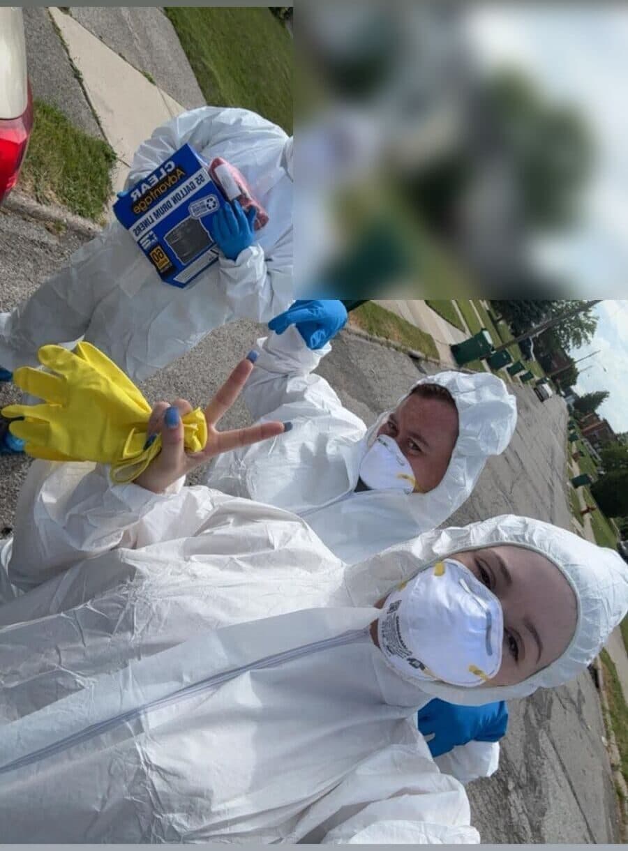 Three crew members in full hazmat suits, masks and gloves ready to start a job