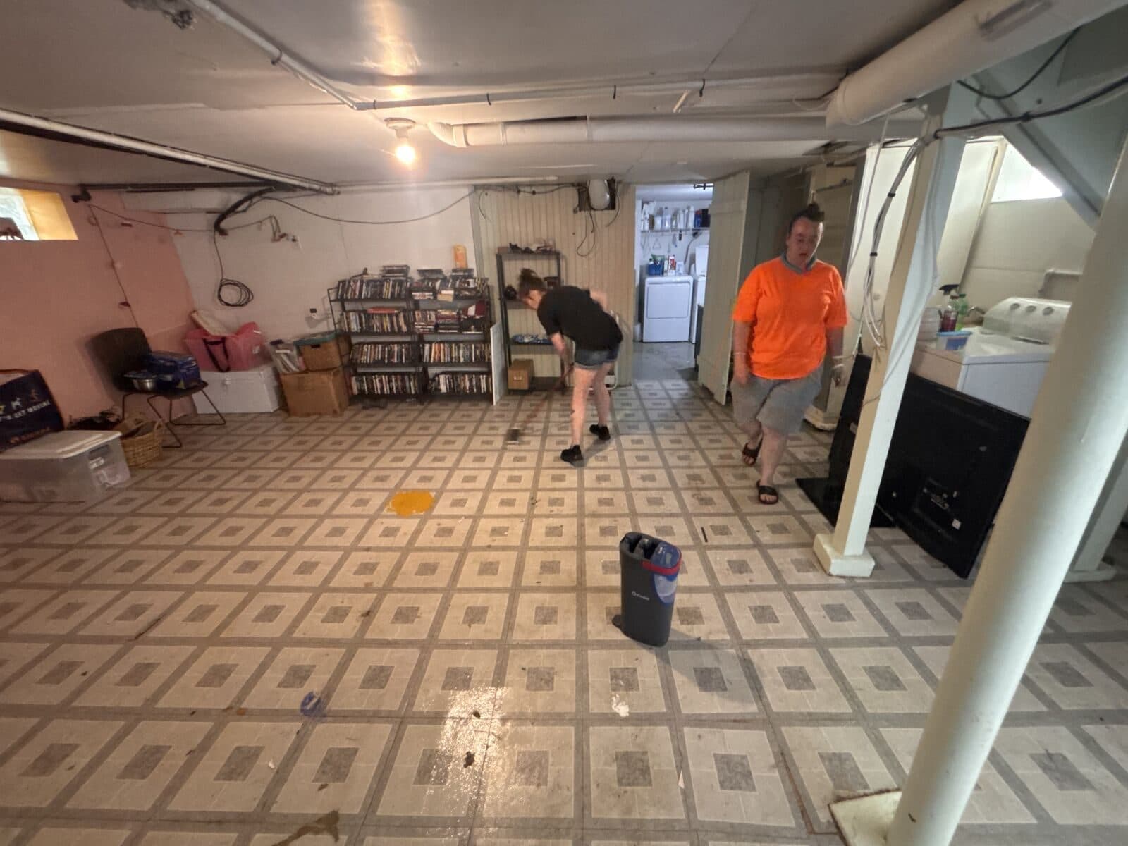 Two crew members working in a cleared basement