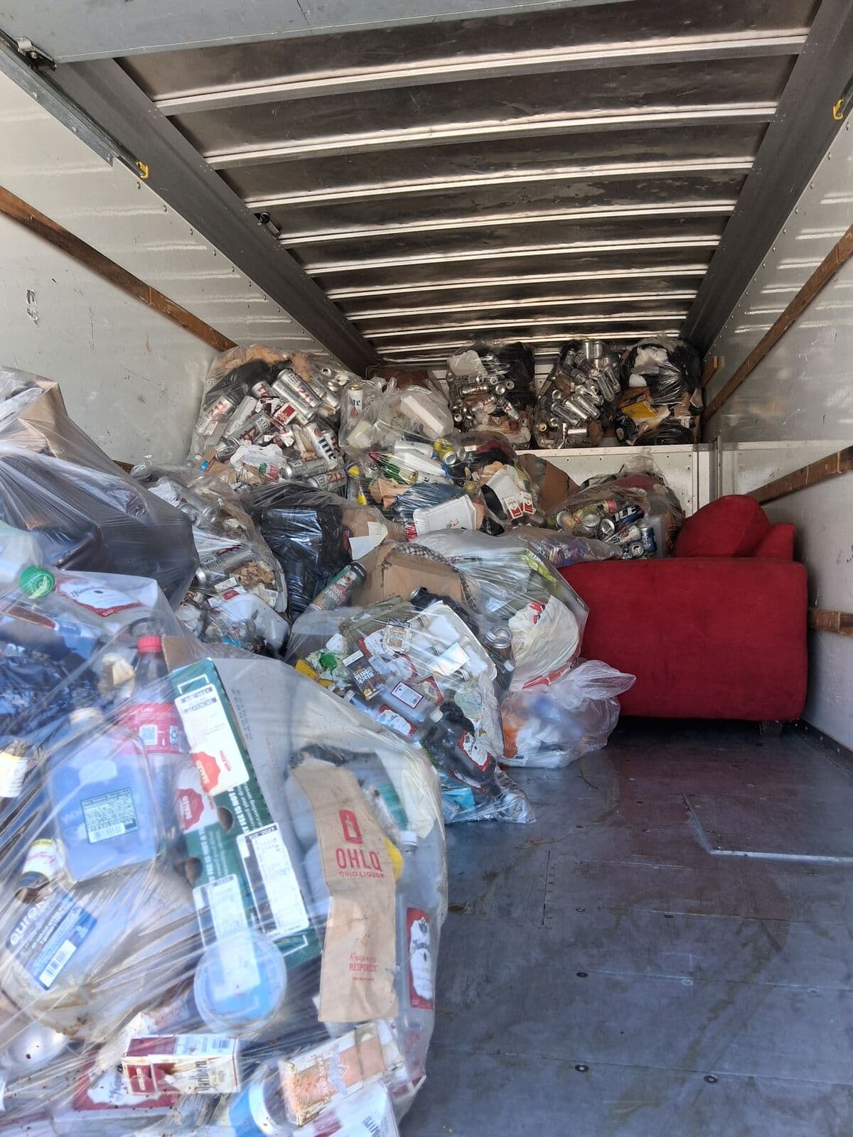 Box truck packed with clear bags of cans and bottles