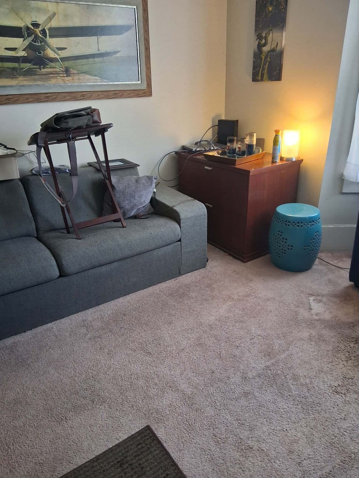 After: Same living room cleared, with sofa and side table and open carpet