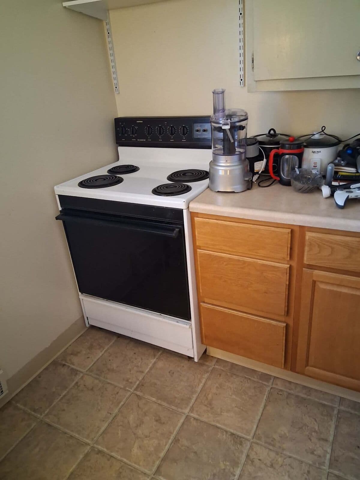 After: Kitchen cleared with stove, cabinets and tile floor visible