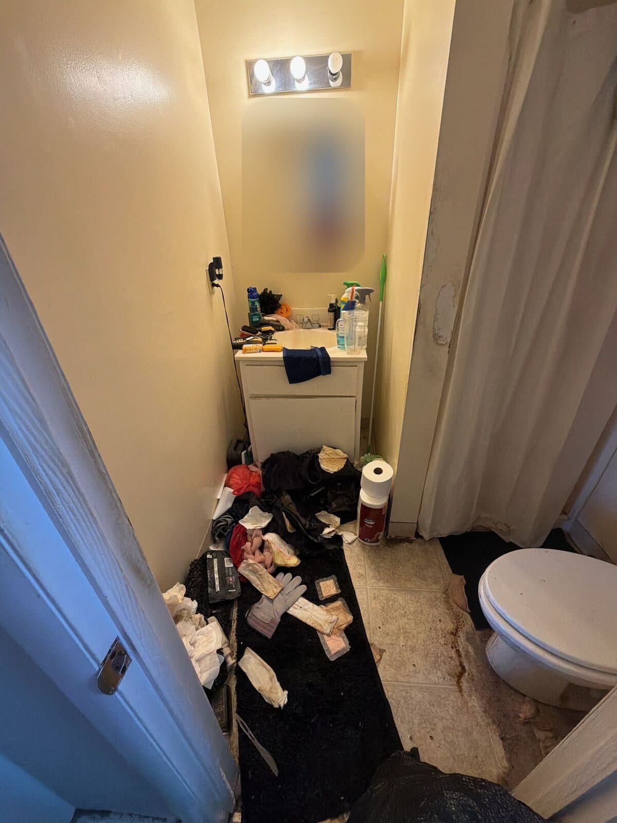 Before: Small bathroom floor covered in debris and trash