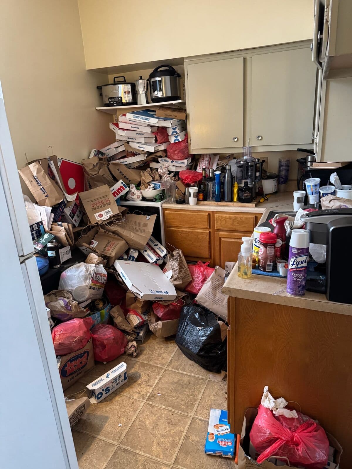 Before: Kitchen floor and counters buried in boxes, bags and food packaging