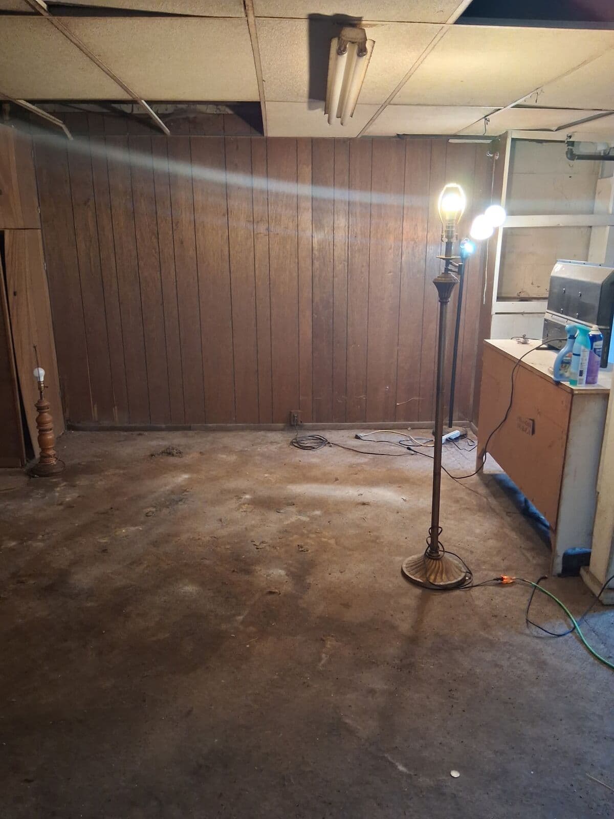 After: Same paneled basement emptied to the bare floor