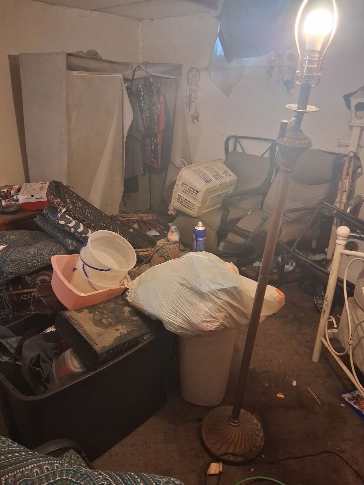 Before: Basement room crowded with furniture, bins and bags