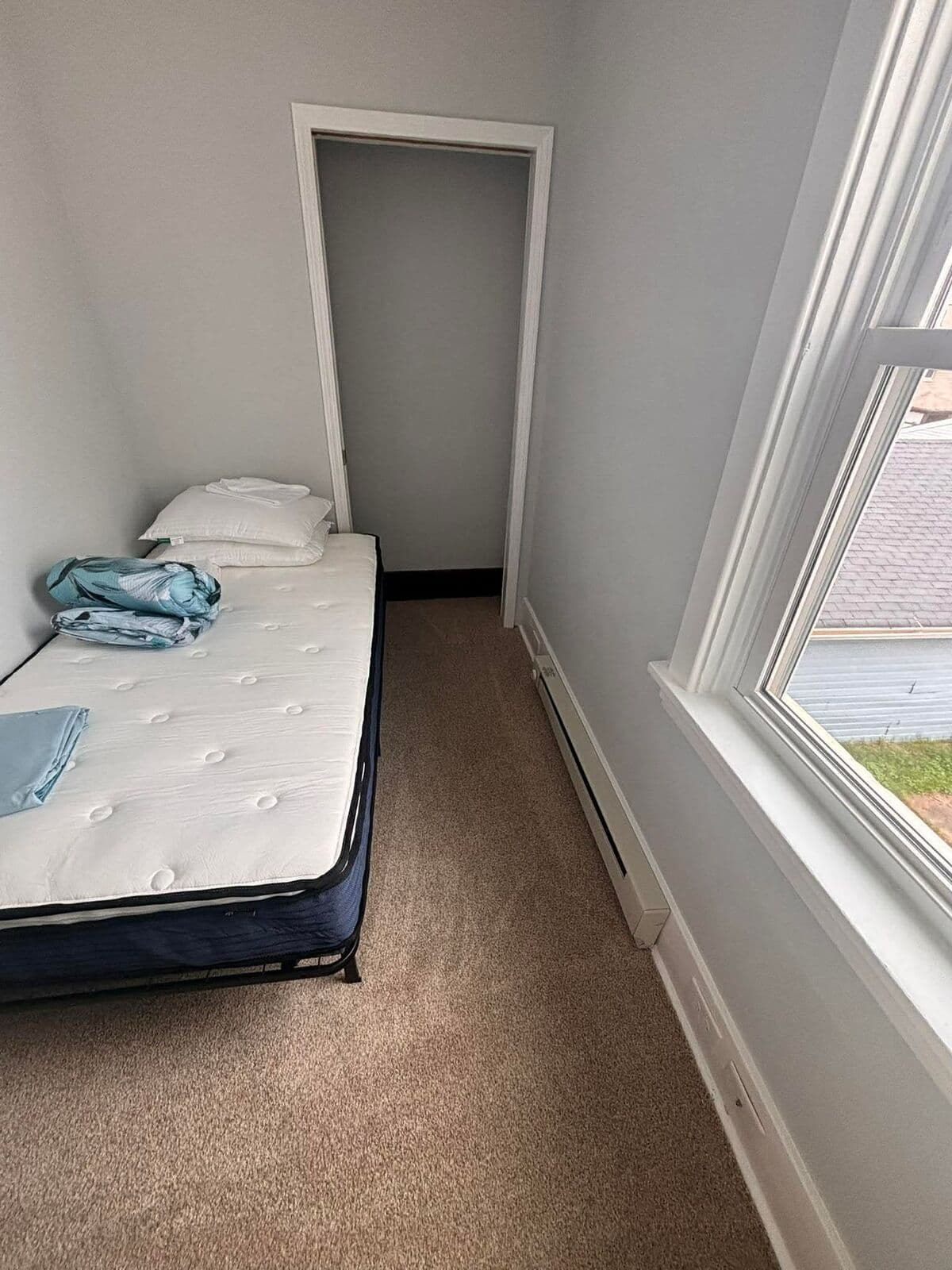 After: Bedroom cleared with a made-up bed and open floor