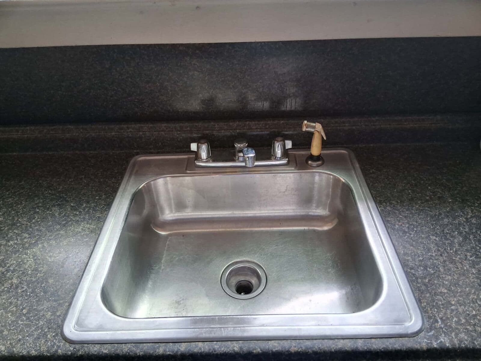 After: Same kitchen sink scrubbed clean on a clear countertop