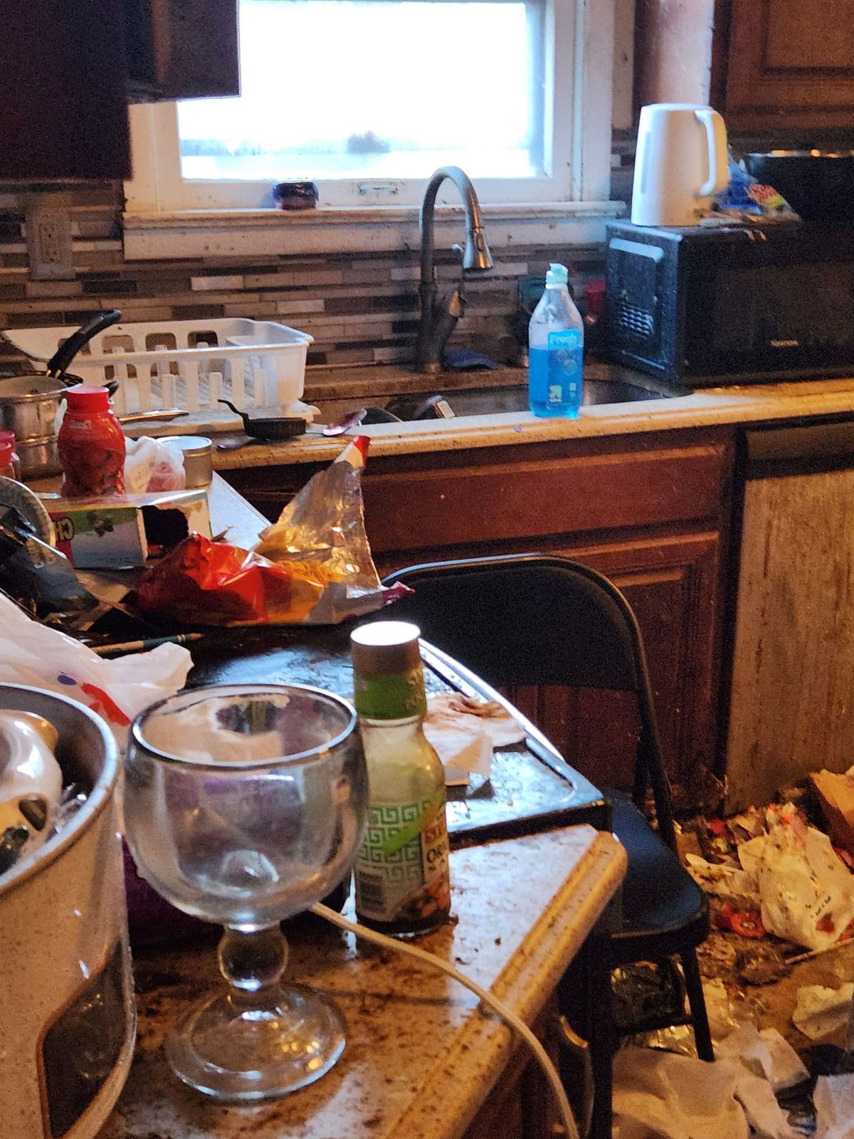 Before: Kitchen counter and floor piled with dishes, food containers and trash