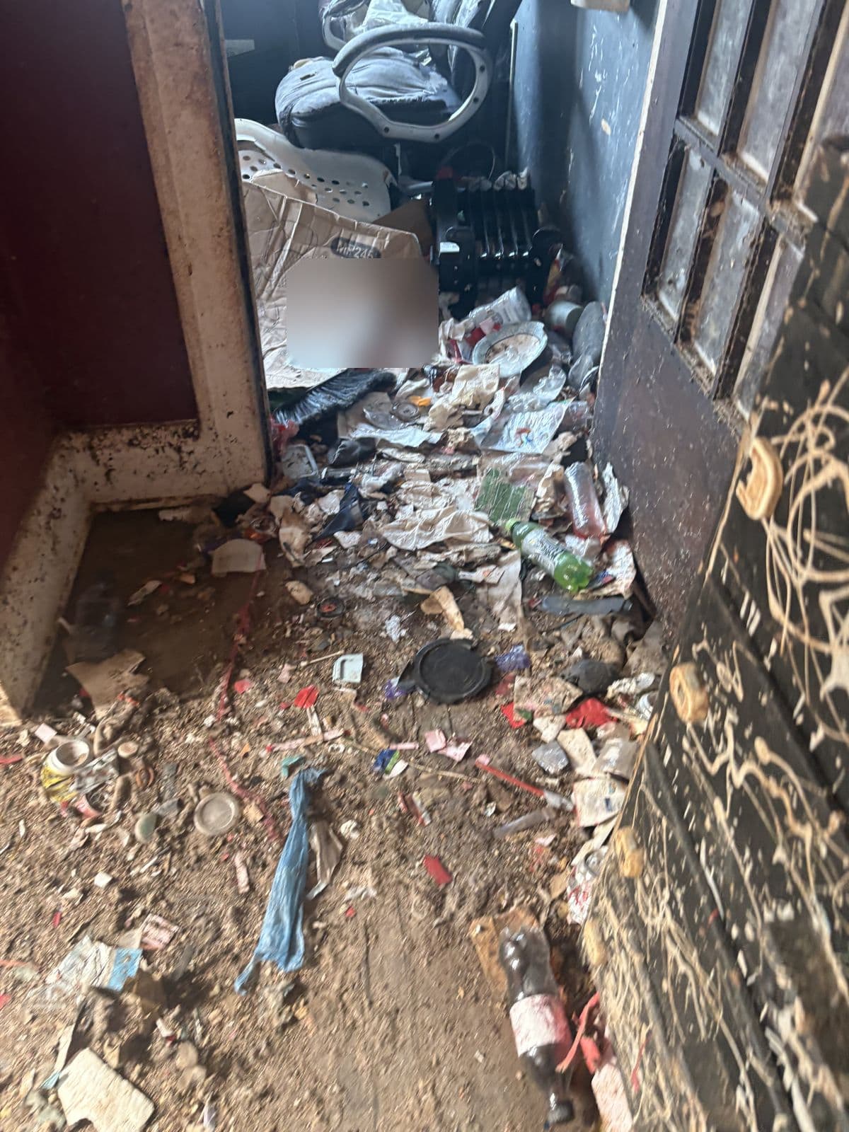 Before: Red-walled room with the floor covered in papers, bottles and trash beside a paned door