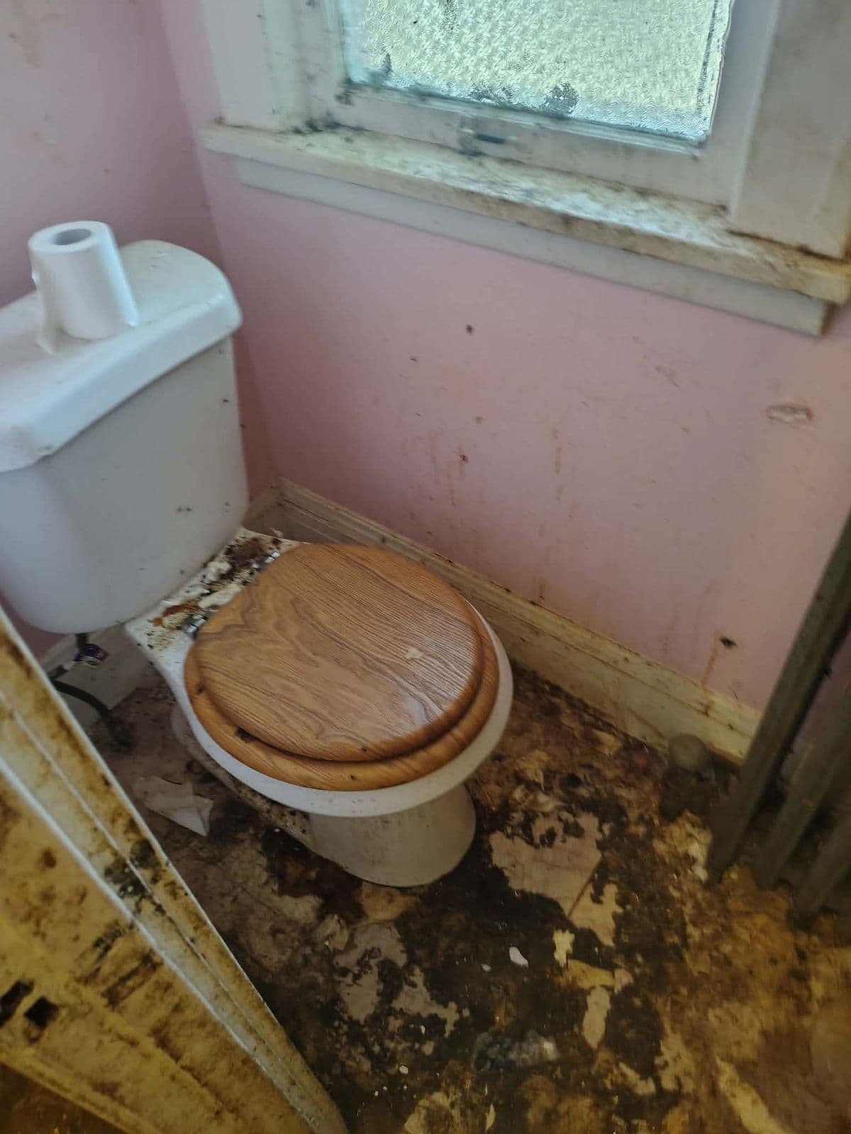 Before: Small bathroom with a filthy toilet and a floor covered in grime and debris