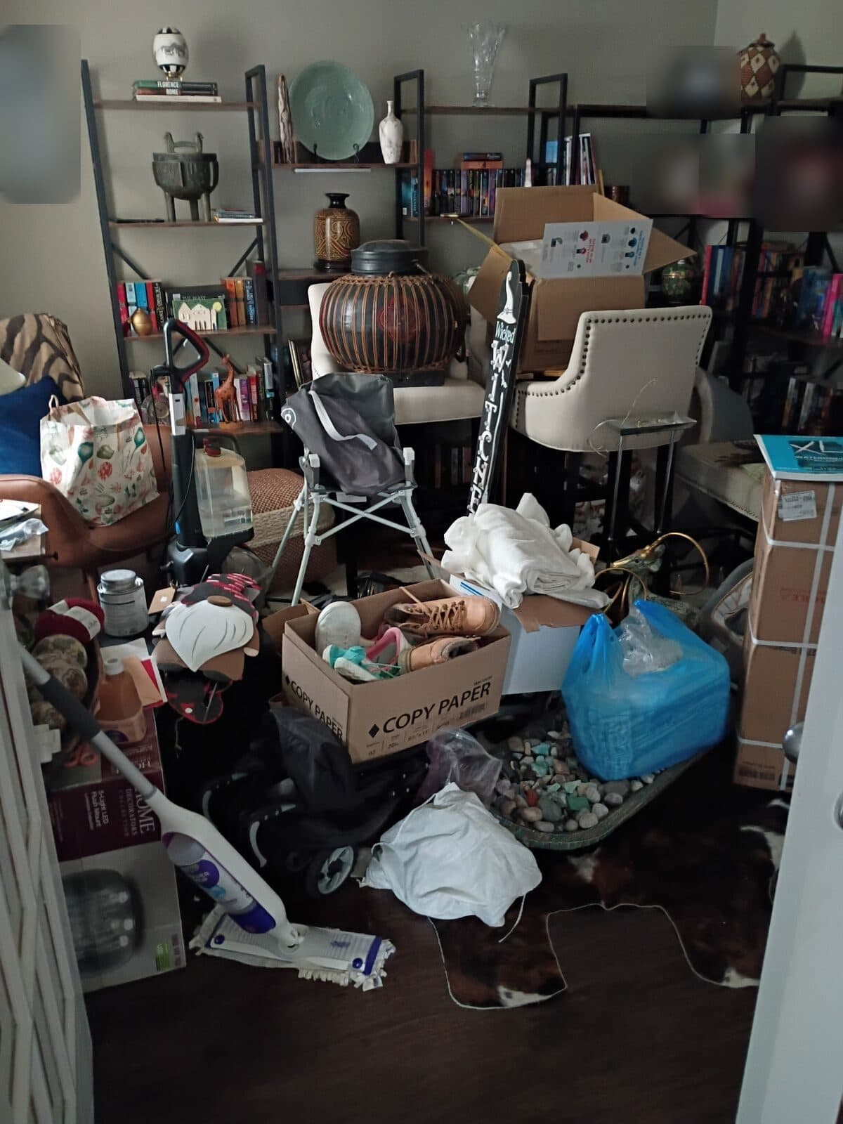Before: Sitting room crowded with boxes, bags and loose items