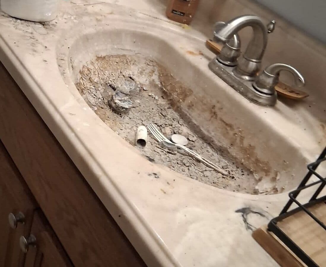 Before: Bathroom sink filled with dirt and debris